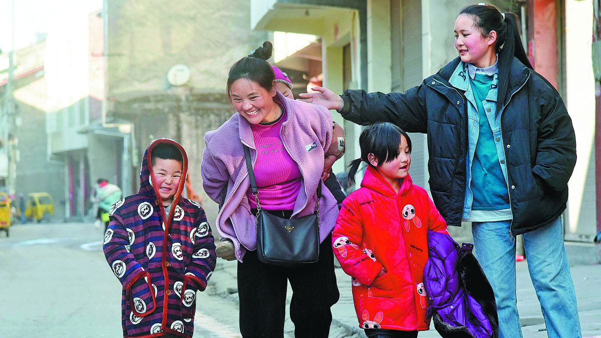 Bamuyubumu y sus hijos caminan por una calle de su ciudad natal en la prefectura autónoma de la etnia yi de Liangshan, provincia de Sichuan, en enero. ZHOU KE / XINHUA