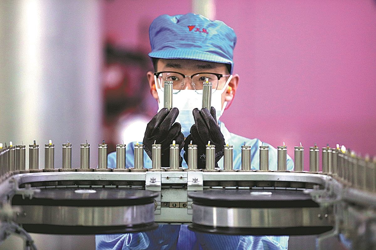 Un trabajador de un taller automatizado en Huzhou, provincia de Zhejiang, revisa productos de baterías de litio en una fábrica. XU XU / XINHUA