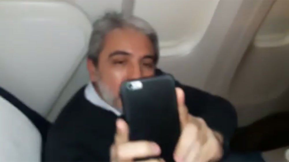 Escracharon a Aníbal Fernández en el vuelo a Londres, él fotografió a quienes lo fimaban y dijo que los iba a buscar