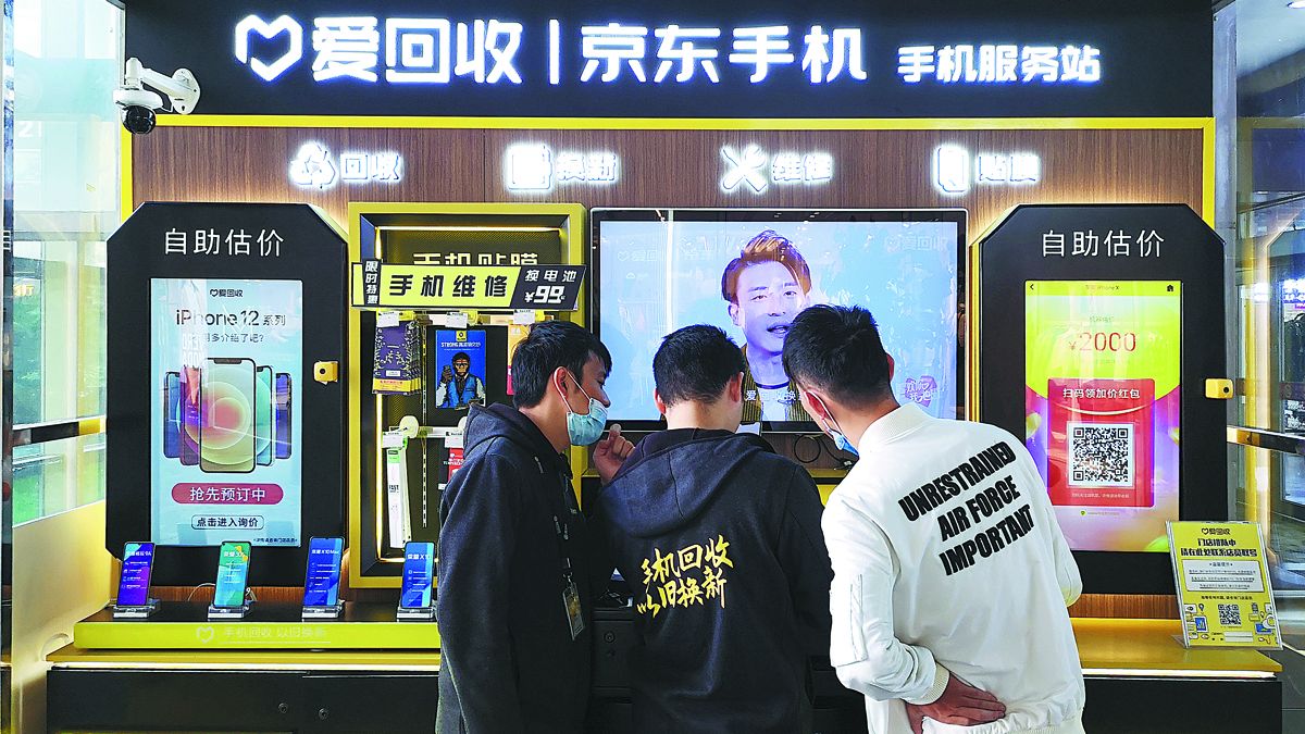 Un consumidor (derecha) revisa móviles de segunda mano en una estación de reciclaje de teléfonos All Things Renew en Shanghai en octubre. REN YUMING / PARA CHINA DAILY