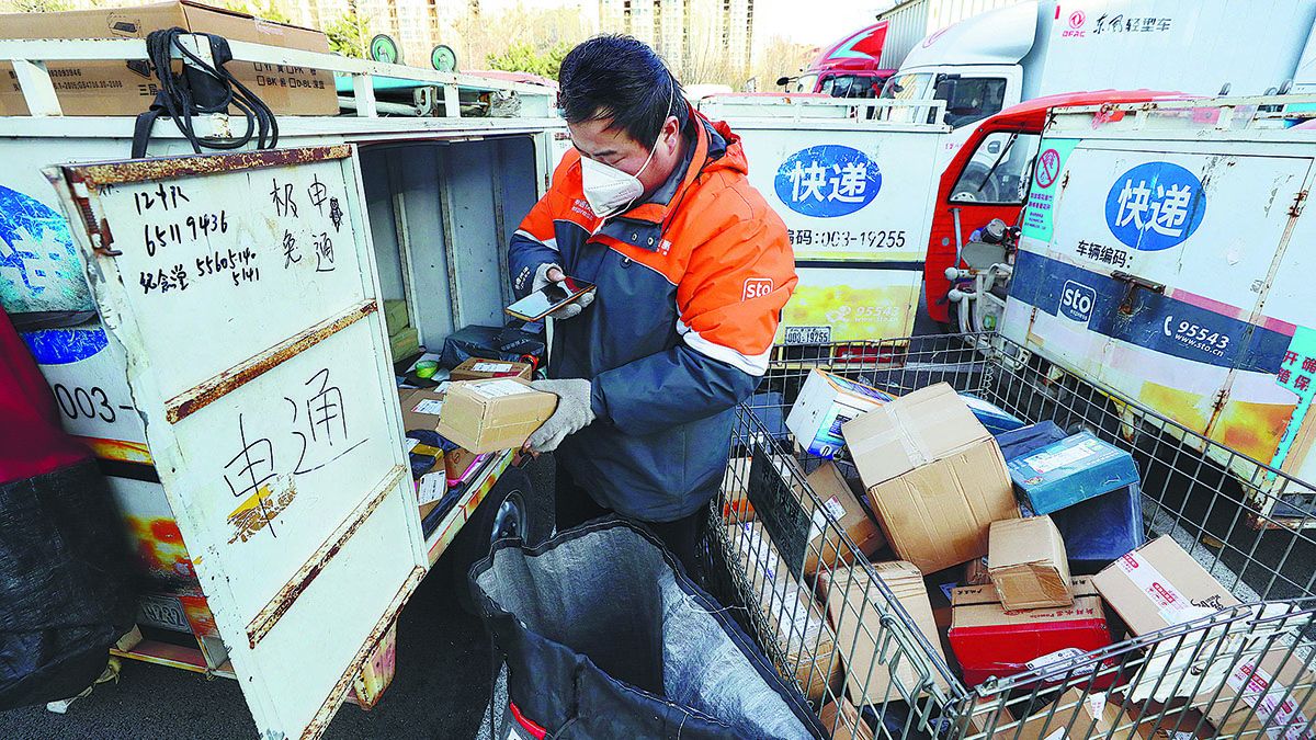Un cartero escanea códigos QR en paquetes antes de entregarlos en Beijing el mes pasado. ZHU XINGXIN / CHINA DAILY