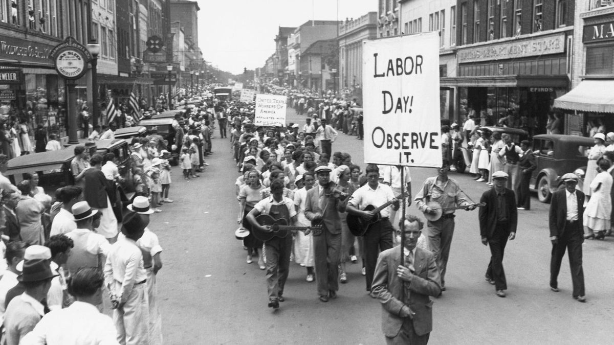 Trabajadores de Gastonia, Carolina del Norte, marchando con determinación en 1934 durante el desfile del Día del Trabajador, unidos en la lucha por sus derechos laborales y mejores condiciones de vida Trabajadores de Gastonia, Carolina del Norte, marchando con determinación en 1934 durante el desfile del Día del Trabajador, unidos en la lucha por sus derechos laborales y mejores condiciones de vida