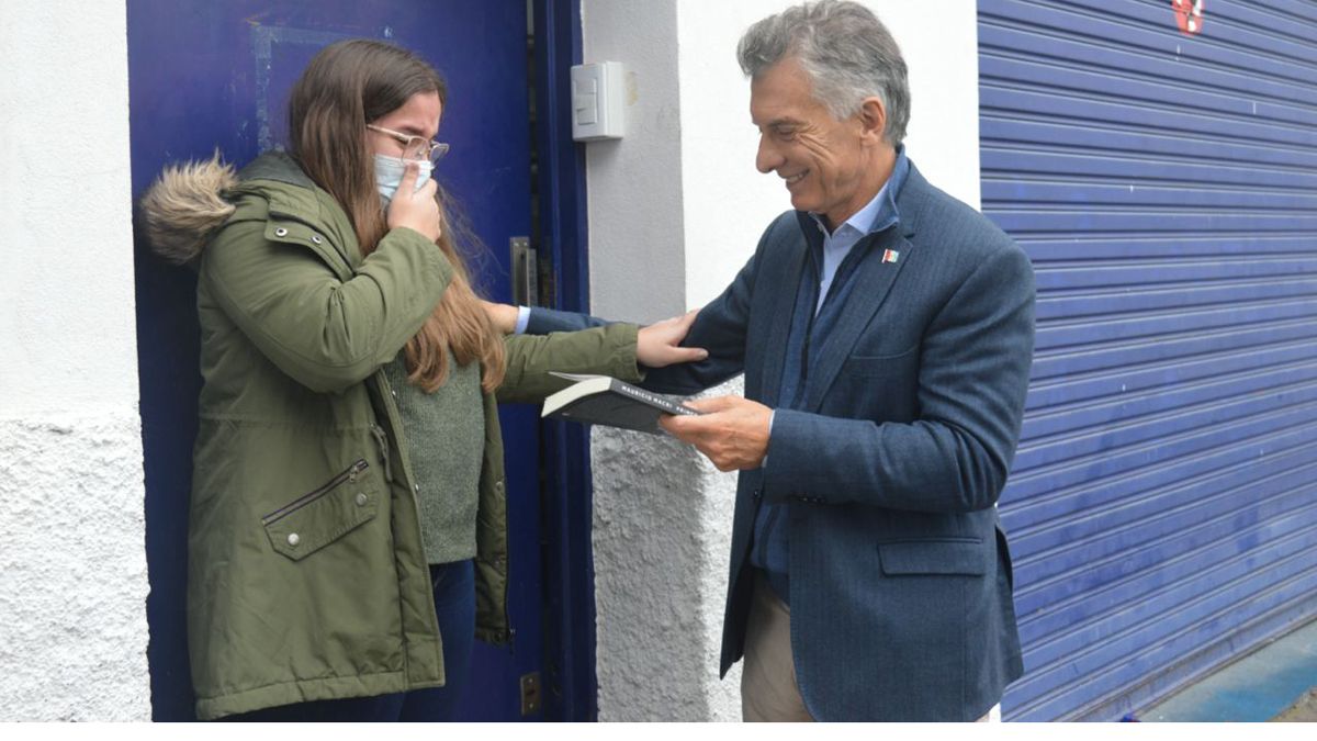Mauricio Macri entrega uno de sus libros a una seguidora. El ex presidente afronta problemas con la Justicia.