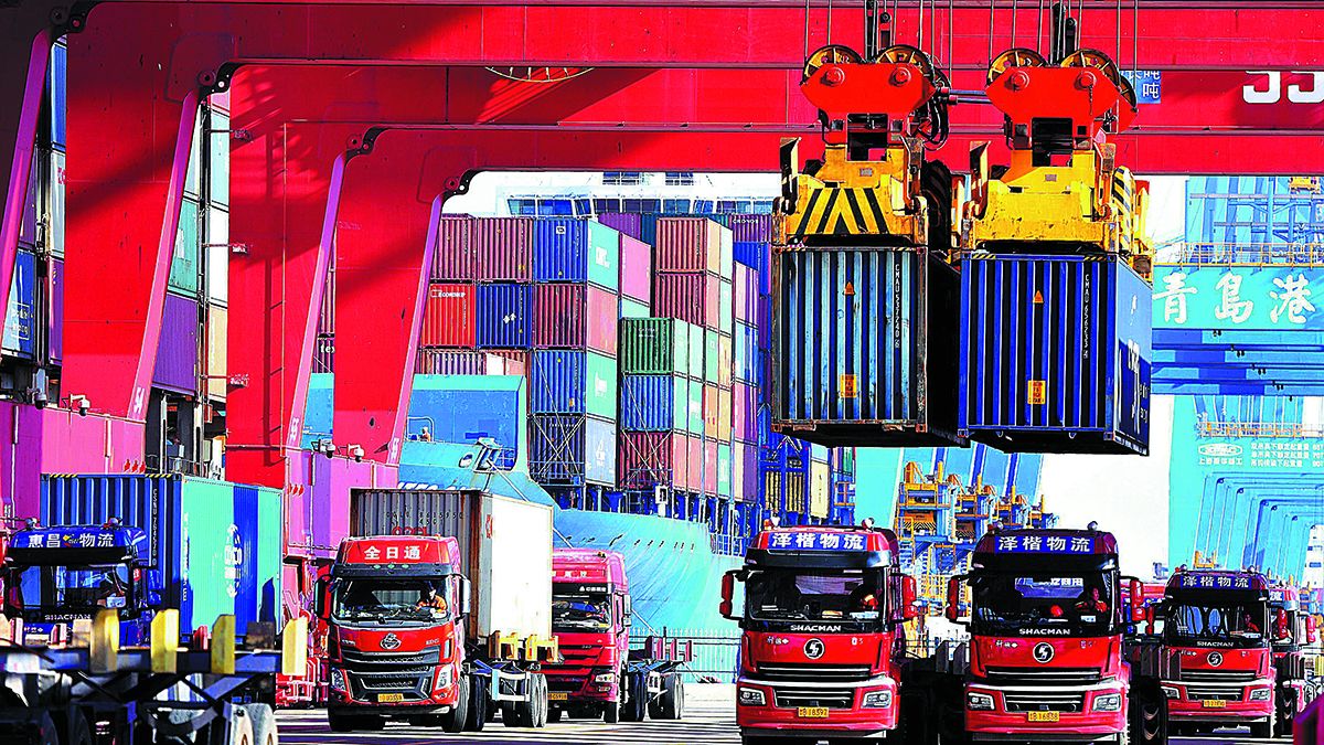 Las grúas cargan contenedores de comercio exterior en una terminal portuaria en Qingdao