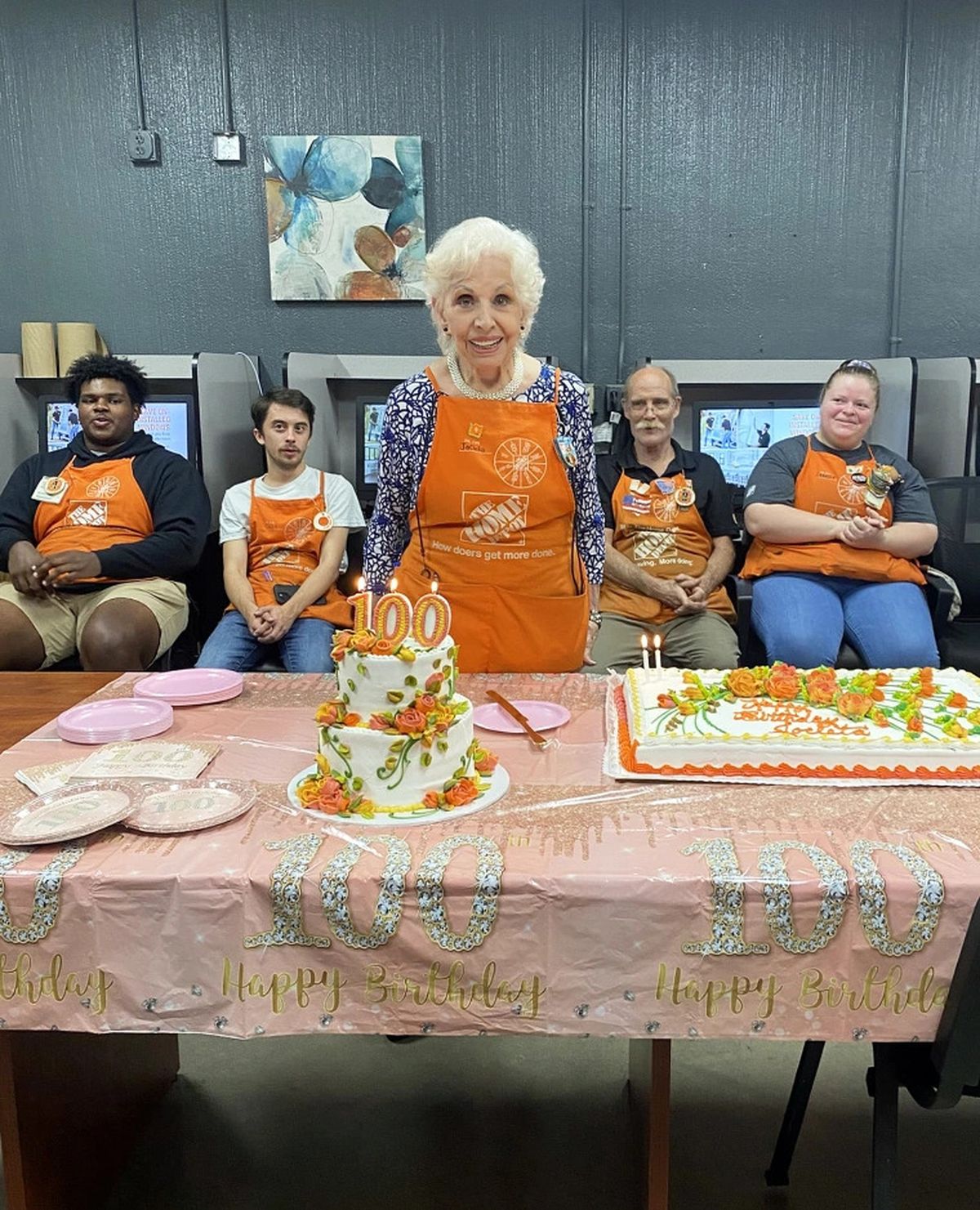 La mujer de 100 años compartiendo su cumpleaños con los compañeros de trabajo.