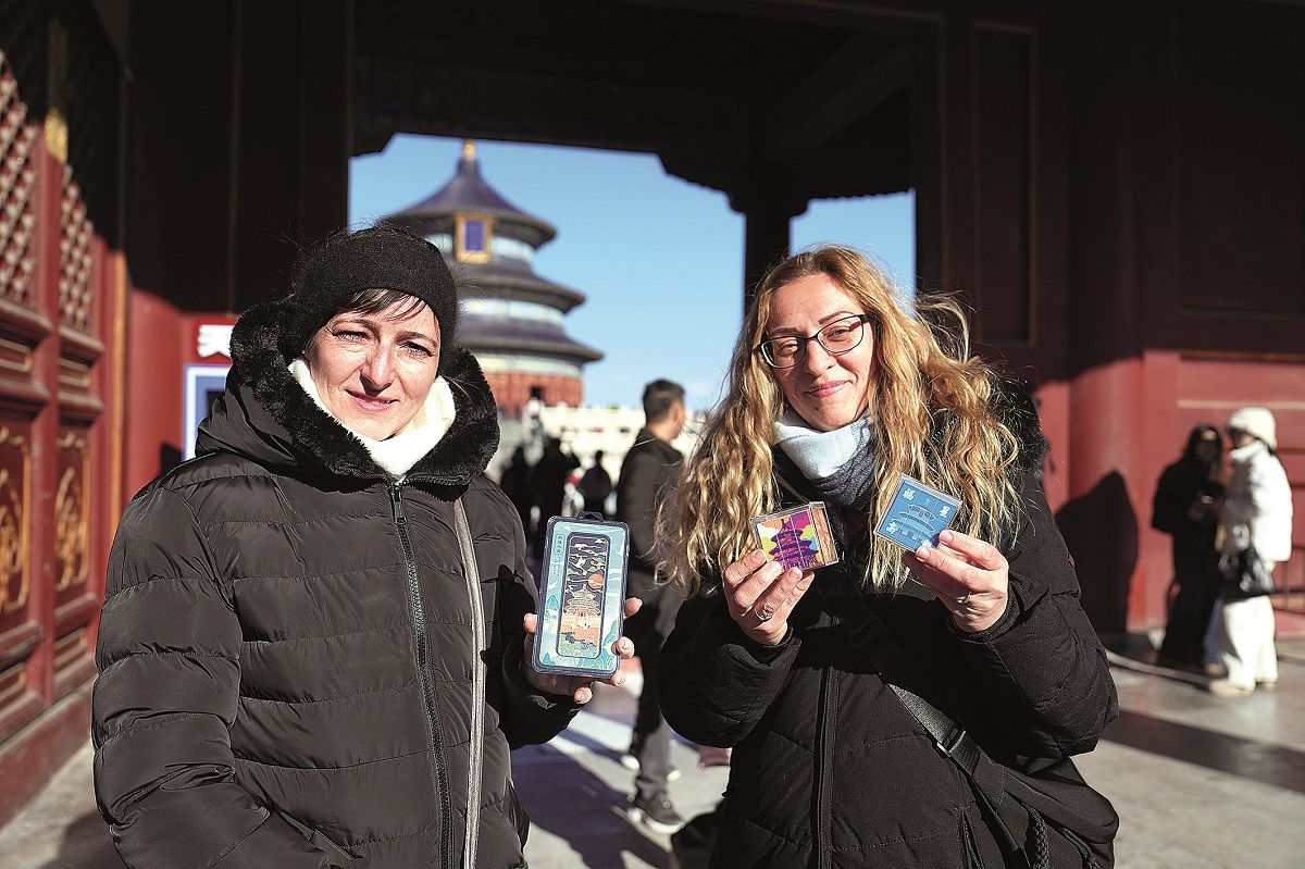 Dos turistas húngaras muestran recuerdos que compraron en el Parque del Templo del Cielo en Beijing el 5 de diciembre. CHEN HAOQUAN / XINHUA
